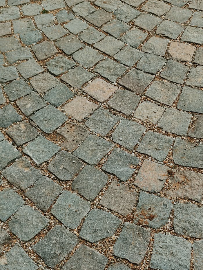 A rustic cobblestone pavement in Romania showcasing a textured, earthy surface with rough stones.